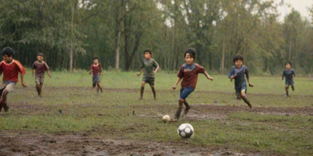Blurry action shot of children playing soccer in a muddy field, their clothes covered in dirt, soft focus on the ball as it flies through the air, distant trees swaying in the breeze.