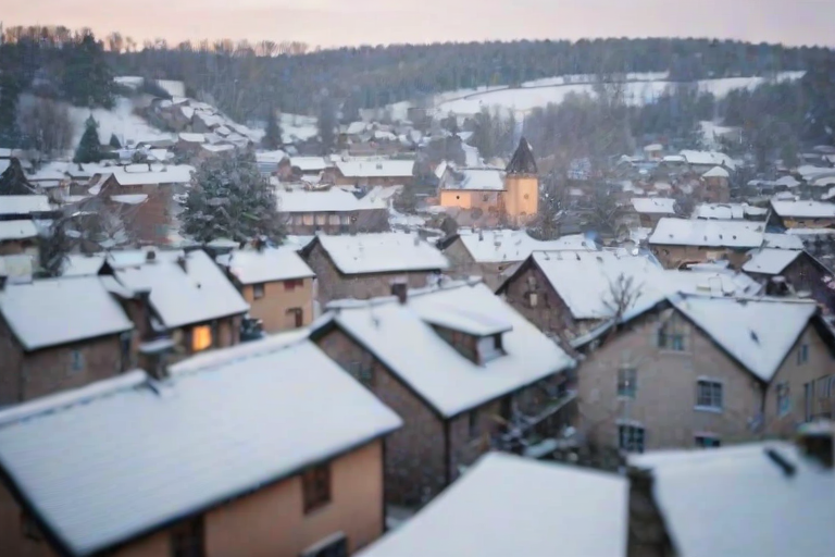 Soft-focus image of a peaceful snowy landscape, with gently falling snowflakes covering a quiet village, soft light reflecting off the rooftops and creating a dreamy atmosphere.