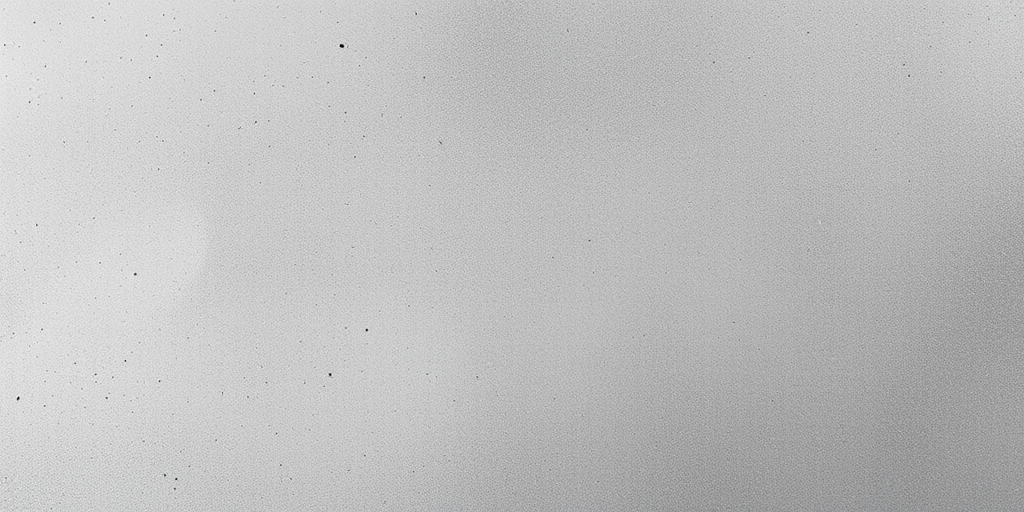 Create a high-resolution abstract texture with a soft gradient from dark to light gray, featuring subtle rough edges and scattered dark speckles, captured with a Canon EOS R5, 50mm f/1.2 lens, ISO 100, aperture f/8, focal length 50mm, with a shallow depth of field for a smooth background.