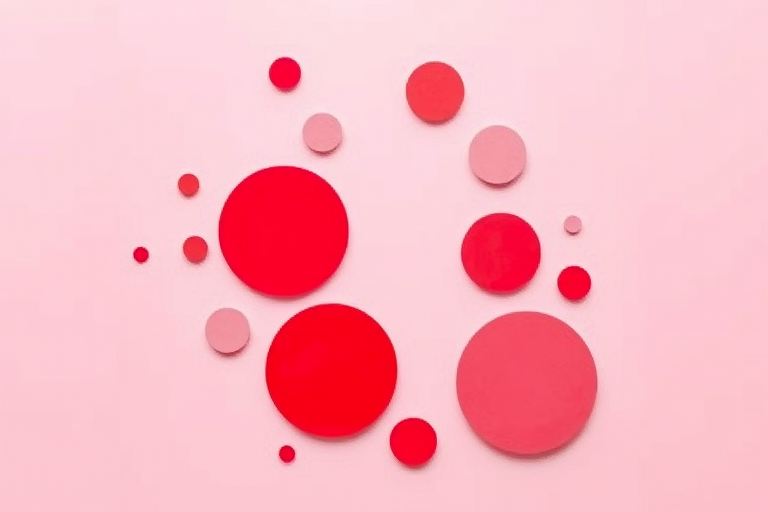 Create an abstract design featuring varying sizes of circles in shades of red and pink on a soft pink background, using a Canon EOS R5, 50mm lens, f/2.8, ISO 100, 1/125 sec, shot from a top-down view, in natural light for vibrant colors and enhanced image quality.