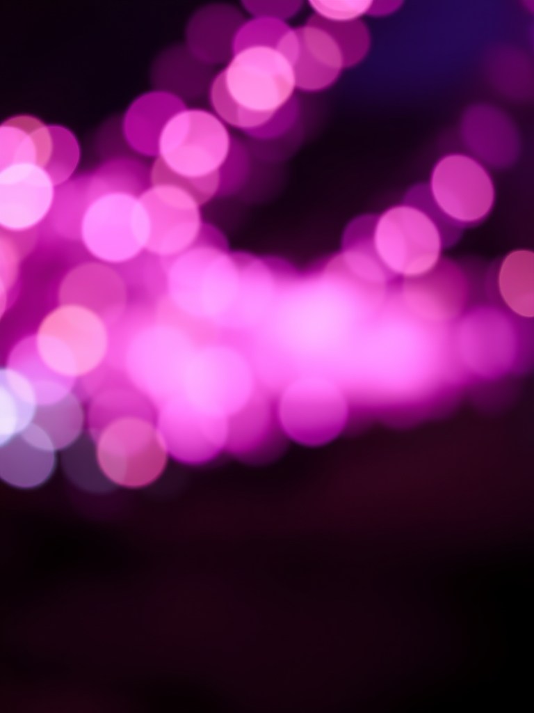 Create an abstract image of swirling bokeh lights in shades of purple, pink, and gold, with a soft focus; use a 50mm lens at f/1.8, ISO 100, and a shutter speed of 1/60s; capture from a slightly angled view with a DSLR camera to enhance depth and detail.