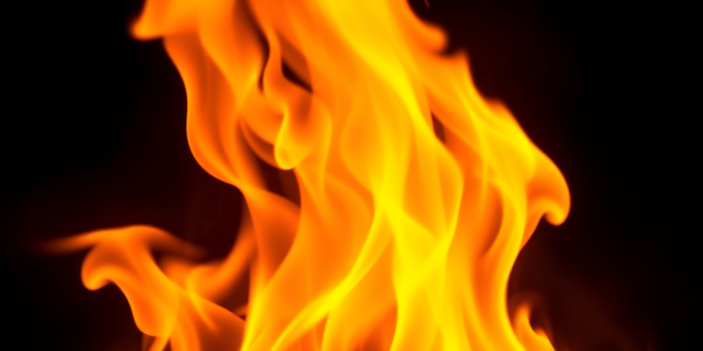 Create a vibrant fire design with a smooth gradient from yellow to orange, using a DSLR camera, 50mm lens, f/1.8 aperture, ISO 100, 1/200 sec shutter speed, in a well-lit studio setup with soft diffused lighting.