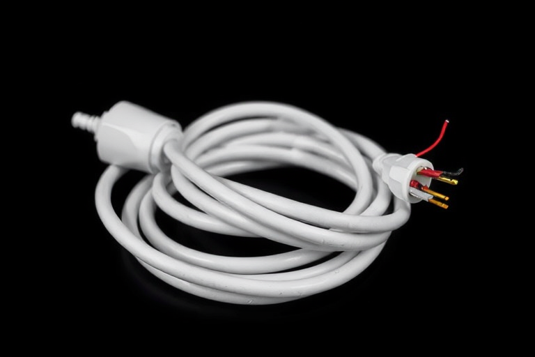 Generate a high-resolution image of a coiled white electrical extension cord with a plug at one end and exposed wires at the other end, using a DSLR camera with a 50mm lens, aperture f/2.8, ISO 100, and a soft diffused lighting setup to enhance clarity and detail.