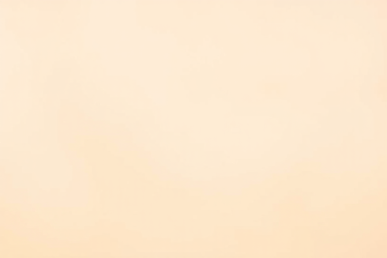 Create a smooth gradient background transitioning from light peach to cream with a soft focus effect, shot with a Canon EOS R5, 50mm lens, f/1.8 aperture, ISO 100, in natural light for enhanced color depth.
