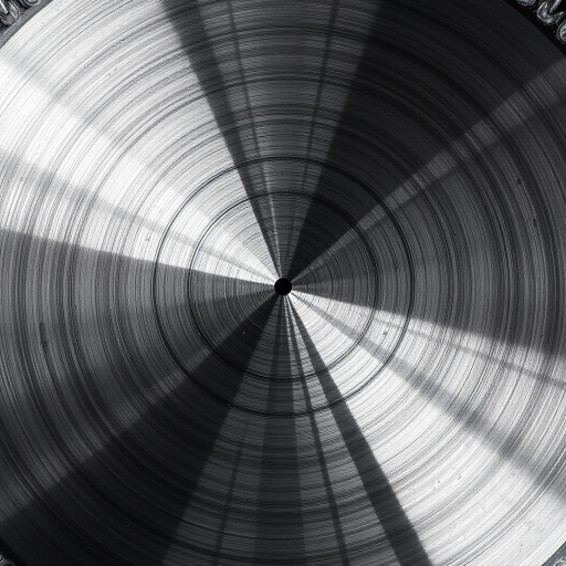 Create a high-resolution image of a circular saw blade, with a sharp, metallic finish, 85mm focal length, f/11 aperture, ISO 100, macro lens, centered view, soft lighting to highlight details.