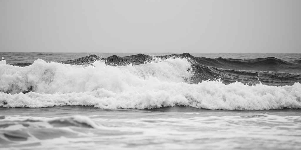 ocean waves crashing in black and white, high contrast, 50mm lens, f/8 aperture, ISO 100, 1/250 shutter speed, captured from a low angle with a slight tilt for dramatic effect, DSLR camera