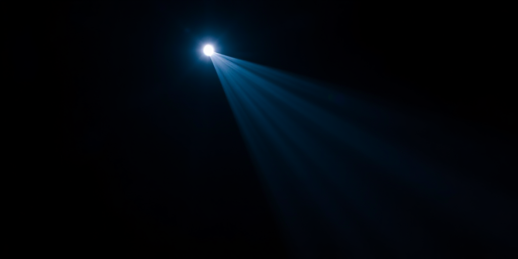 Spotlight beams in a dark space, high-resolution, f-stop 4.0, ISO 100, shutter speed 1/60s, captured from a low angle with a DSLR camera for enhanced clarity and contrast.