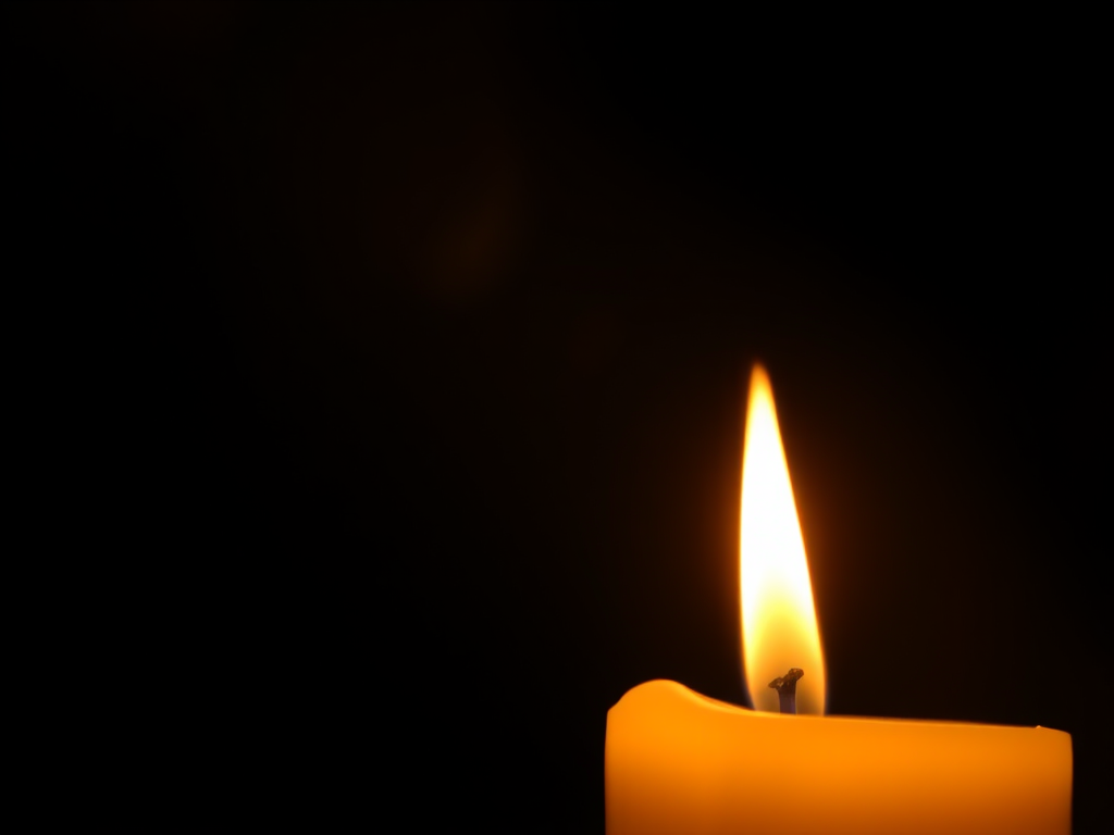 Close-up of a candle’s flame flickering in the darkness, soft golden light illuminating the surrounding area, with shadows dancing on the walls and a sense of calm filling the air.