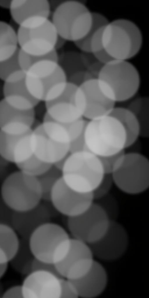 create a bokeh effect image with soft, blurred circles of varying sizes in shades of gray on a black background, using a DSLR camera with a 50mm f/1.8 lens, aperture set to f/1.8, ISO 100, shutter speed 1/200s, shot from eye level in a shallow depth of field to enhance image quality