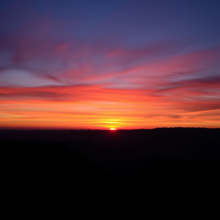 Capture a high-resolution image of a vibrant sunset over a silhouette of mountains, taken with a DSLR camera at f/8 aperture, ISO 100, and a 24mm focal length, using a landscape orientation and soft lighting to enhance colors and contrast.
