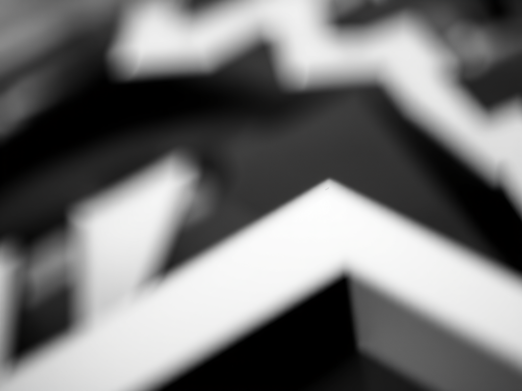 Generate an abstract black and white geometric design with a soft focus effect, shot with a Canon EOS R5, 50mm f/1.2 lens, aperture set to f/2.8, ISO 100, and a shallow depth of field to enhance contrast and detail.